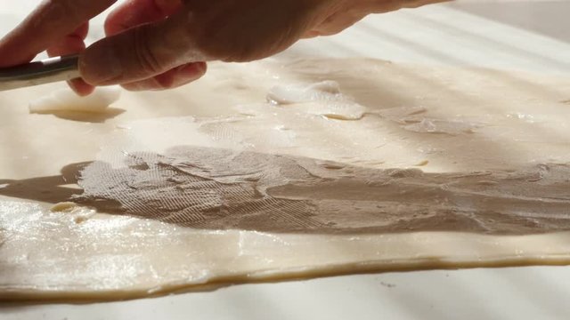 Professional puff pastry making with fat spreading over dough 4K 2160p UltraHD footage - Laminated dough packet on table spread butter 4K 3840X2160 UHD video