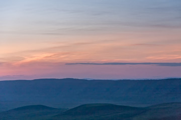 Fototapeta na wymiar Panoramic view of huge Ngorongoro caldera (extinct volcano crater) against evening glow background at dusk. Great Rift Valley, Tanzania, East Africa. 