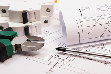 Work tools, electric fuse and rolls of diagrams on construction drawing of house