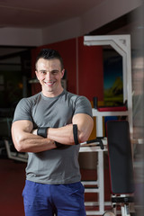 Fototapeta na wymiar Portrait of muscular man with arms crossed in crossfit gym