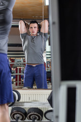 Serious man lifting dumbbells at the gym