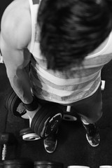Fototapeta na wymiar Top view of sporty man lifting weight at gym