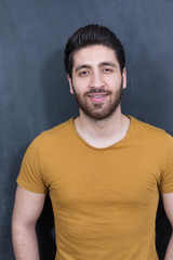 Portrait of a fashionable young man on dark background, chalkboa
