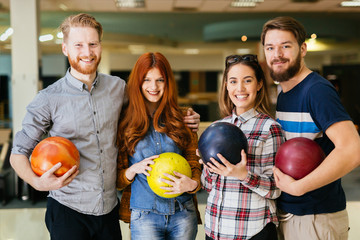 Cheerful friends bowling together