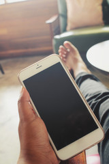 Woman using smart phone on sofa at home