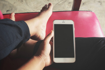 Woman using smart phone on sofa at home
