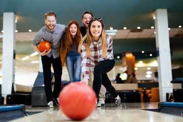 Friends having fun while bowling - obrazy, fototapety, plakaty