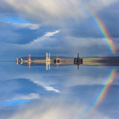 Semi Submersible Oil Rigs and Rainbow with Reflection
