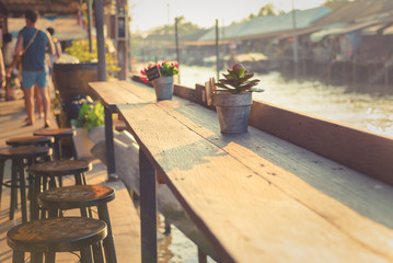 Decoration small plant pot on old wood table and chairs at sunshine
