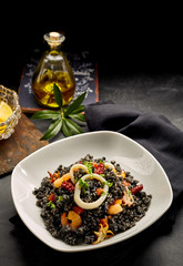 Plate of cooked arroz negro with oil on table