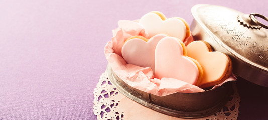 Decorative heart shaped fondant cookies in a tin
