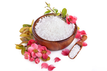 Sea bath salt in bowl and red blossom flowers on white background