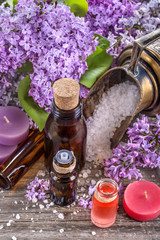 Essential oils and bath salt with a background of lilac