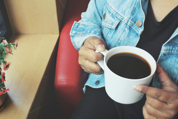 Woman drink black coffee with jeans jacket
