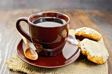 Coffee in brown cup with cookies on board