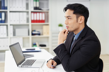 Fototapeta premium nachdenklicher junger mann arbeitet am laptop