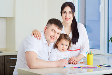 Smiling family drawing together at home