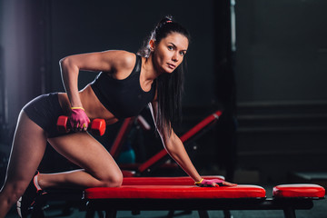 woman exercising dumbbell row at the gym