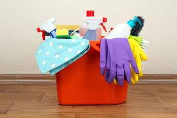 a bucket with detergent and gloves for cleaning stands on the floor