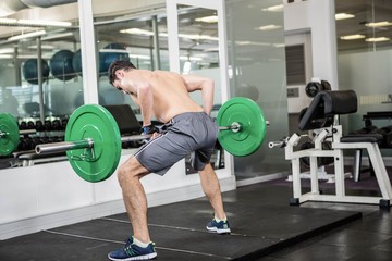 Fototapeta na wymiar Shirtless man lifting barbell