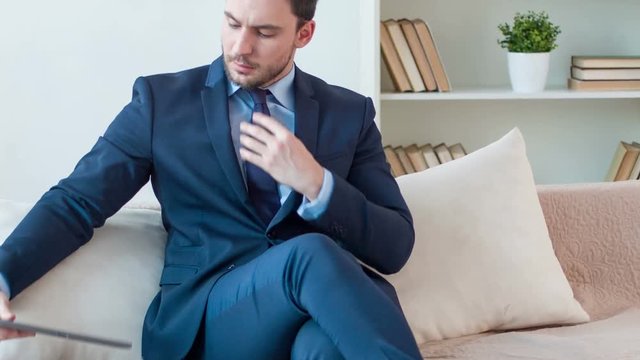 Pleasant man sitting on the sofa