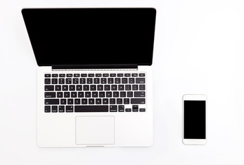 laptop and phone on a white table with space for text