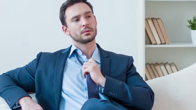  Serious businessman sitting on the sofa  