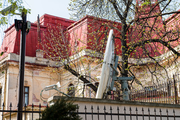 Large parabolic satellite antenna in the backyard of a house