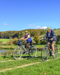 Senioren-Paar macht gutgelaunt eine Radtour