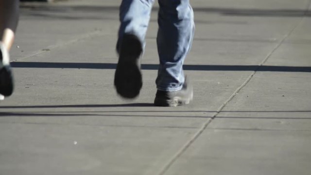 Feet of people jogging on pavement