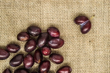 Obraz premium Fresh prune plums in basket on canvas background..