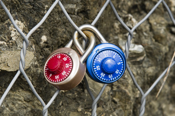 Two Padlocks Combination closed on a metal grid