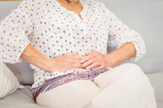 Midsection Of Senior Woman Suffering From Stomach Pain