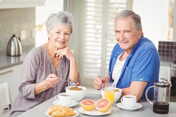 Fototapeta na wymiar Portrait of smiling senior couple having breakfast