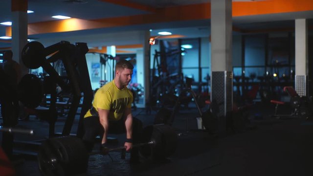 man doing exercises on the buttocks with the rod