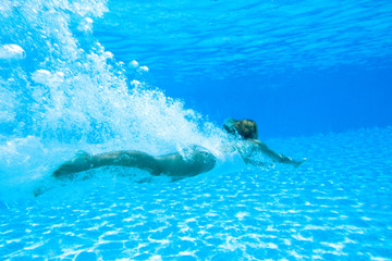 femme nageant dans une piscine sous l'eau