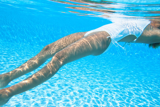 corps d'une femme dans une piscine sous l'eau