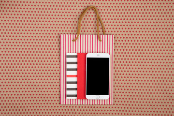 Obraz premium handmade striped shopping bag, gift bags, notepads and smartphone