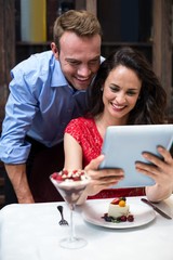 Happy couple using digital tablet