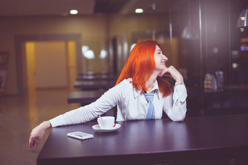 Businesswoman drinking coffee / tea and in a coffee shop.