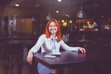 Businesswoman drinking coffee / tea and in a coffee shop.