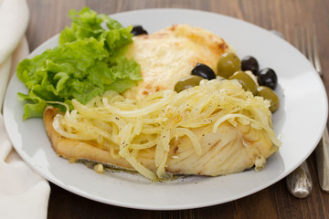 cod fish with onion and mashed potato on white plate