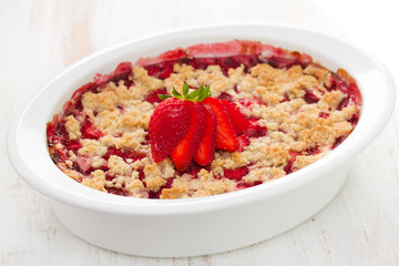 oatmeal strawberry crumble in white dish on white background