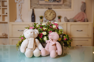 White and pink bear toys sitting near the flowers