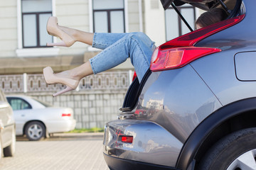 Girls legs in car trunk is wearing heels