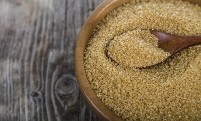 Cane sugar and spoon in a wooden bowl