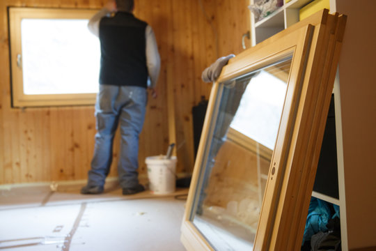 Worker installing new wooden windows