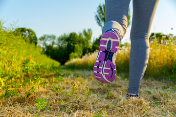 Woman running at sunset in a field