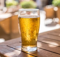 Crédence de cuisine en verre imprimé Bière Verre de bière légère sur la table en bois.