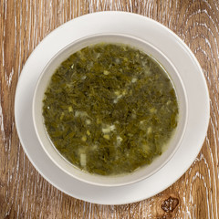 Traditional green dietary  soup in a bowl on wooden background